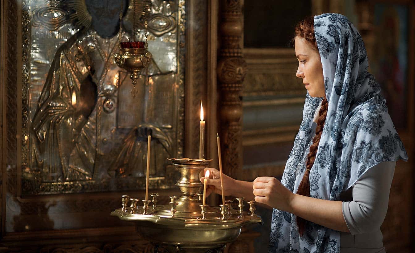 Мария Степановна ставит свечи в церкви